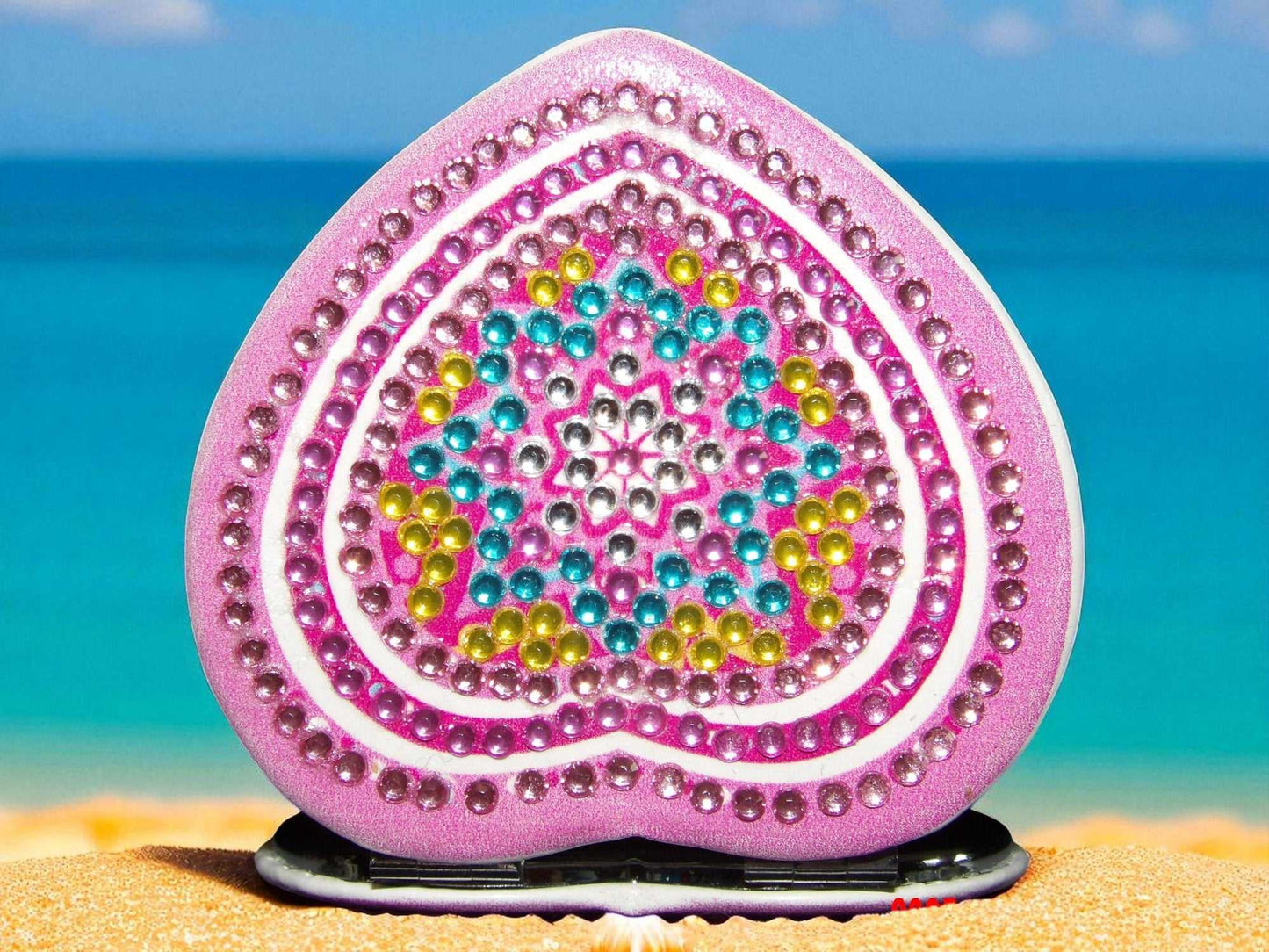 Blue Star Heart mandala design pocket mirror with magnification and regular side on sandy beach background