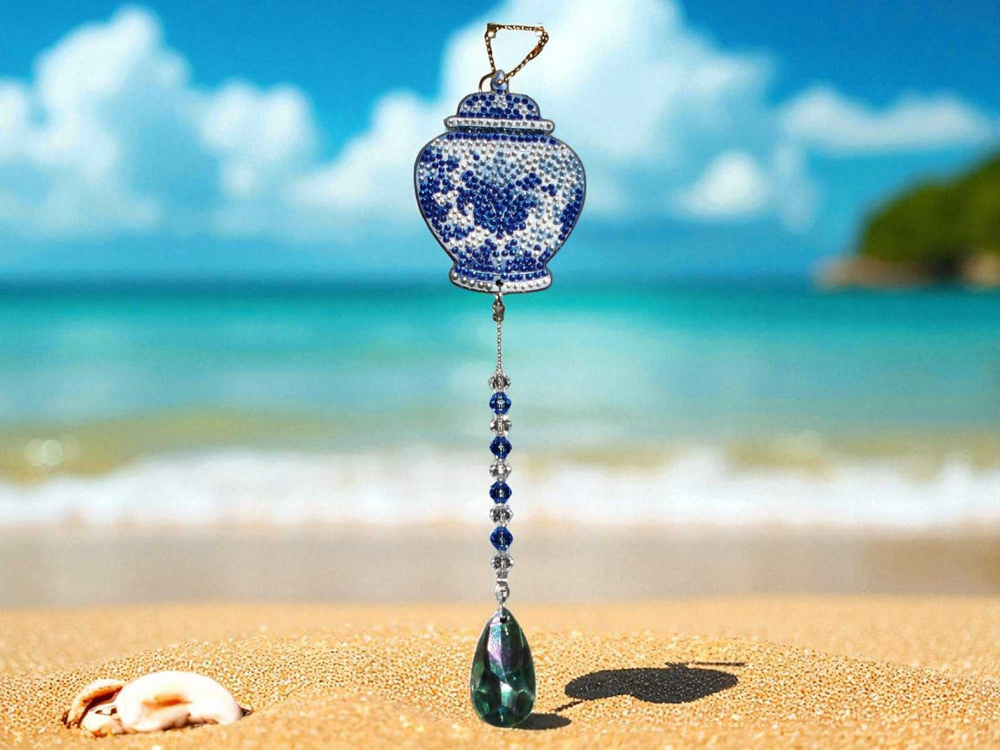 Antique style blue wide pot sun and wind catcher hanging on beach with ocean background