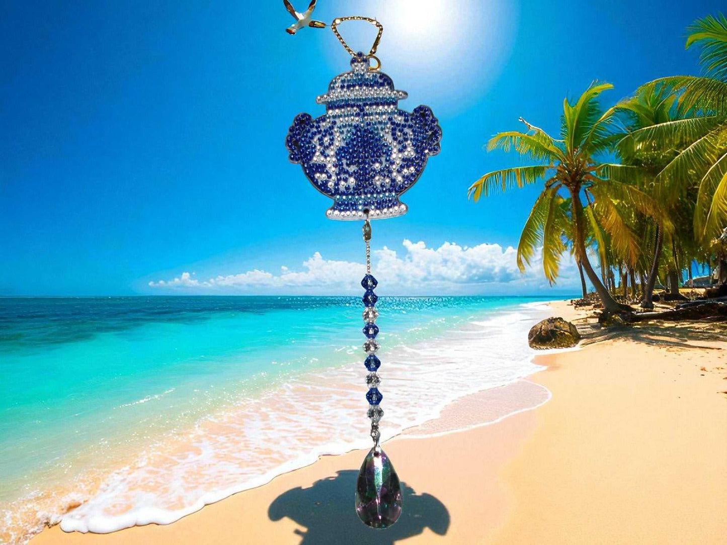 Antique style blue pot sun and wind catcher hanging on tropical beach background