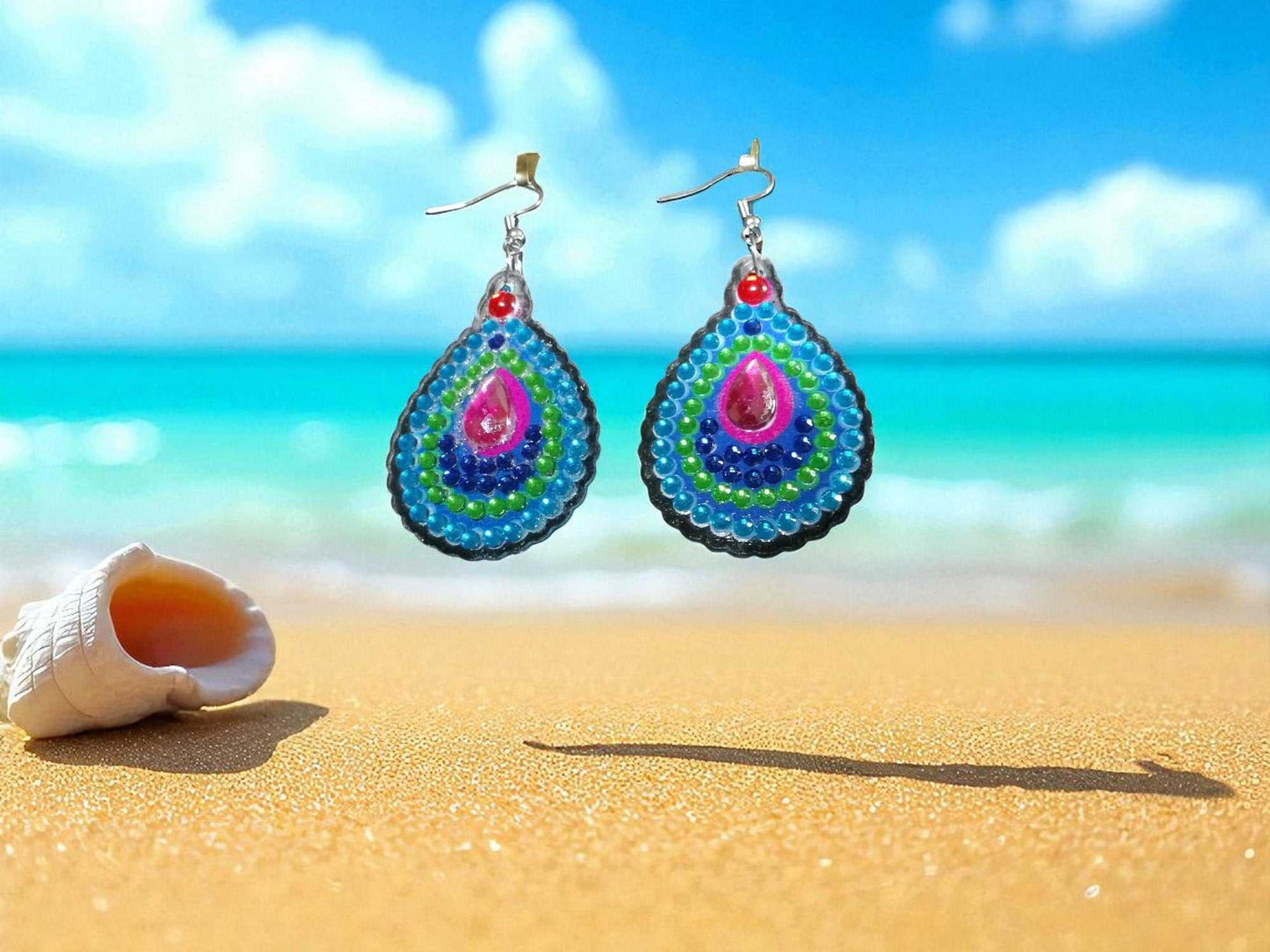 Blue green round earrings with colorful bead design on sandy beach background