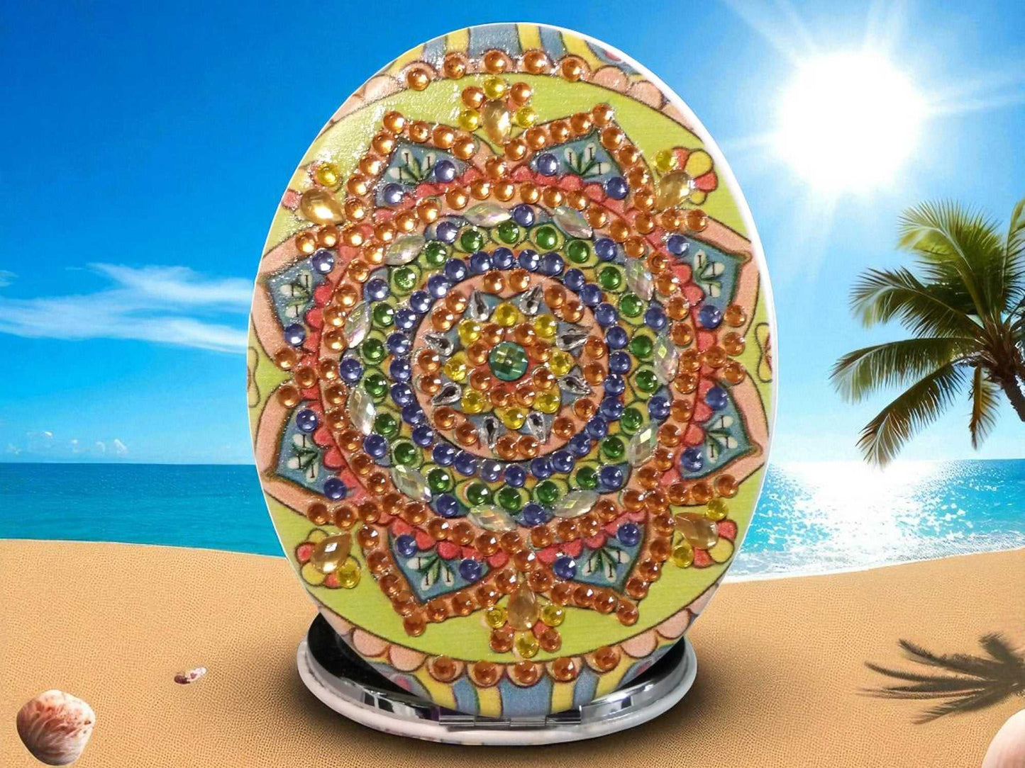 Golden Oblong Pocket Mirror with colorful mandala design and magnification feature on one side, set against a beach background