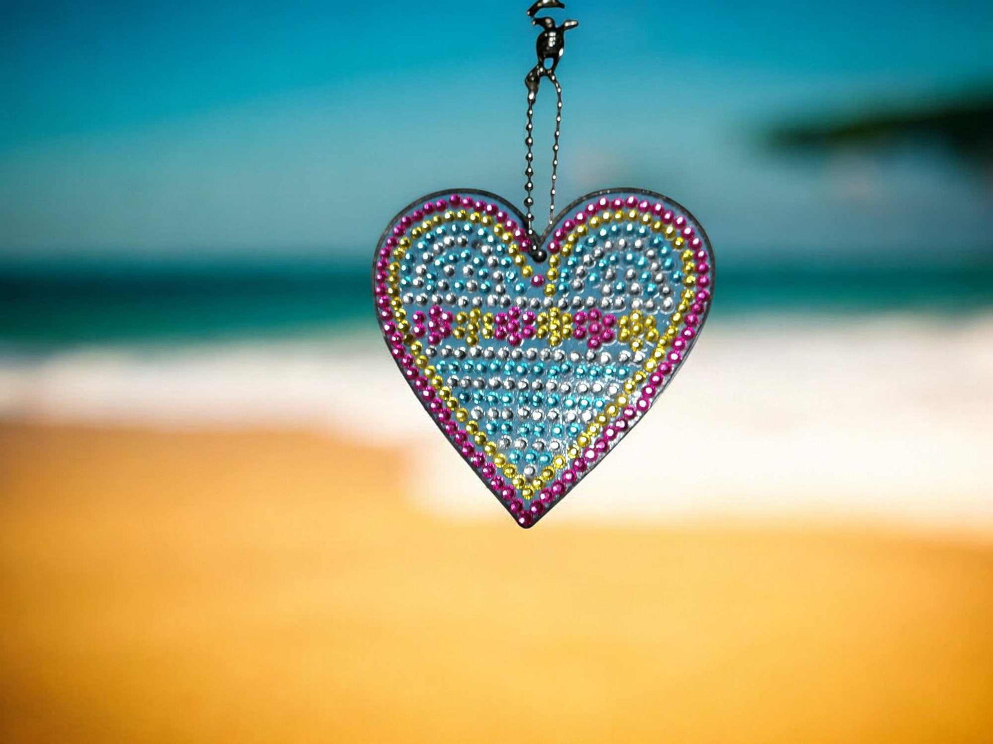 Blue heart-shaped keychain with flowers and beads hanging on a metal chain