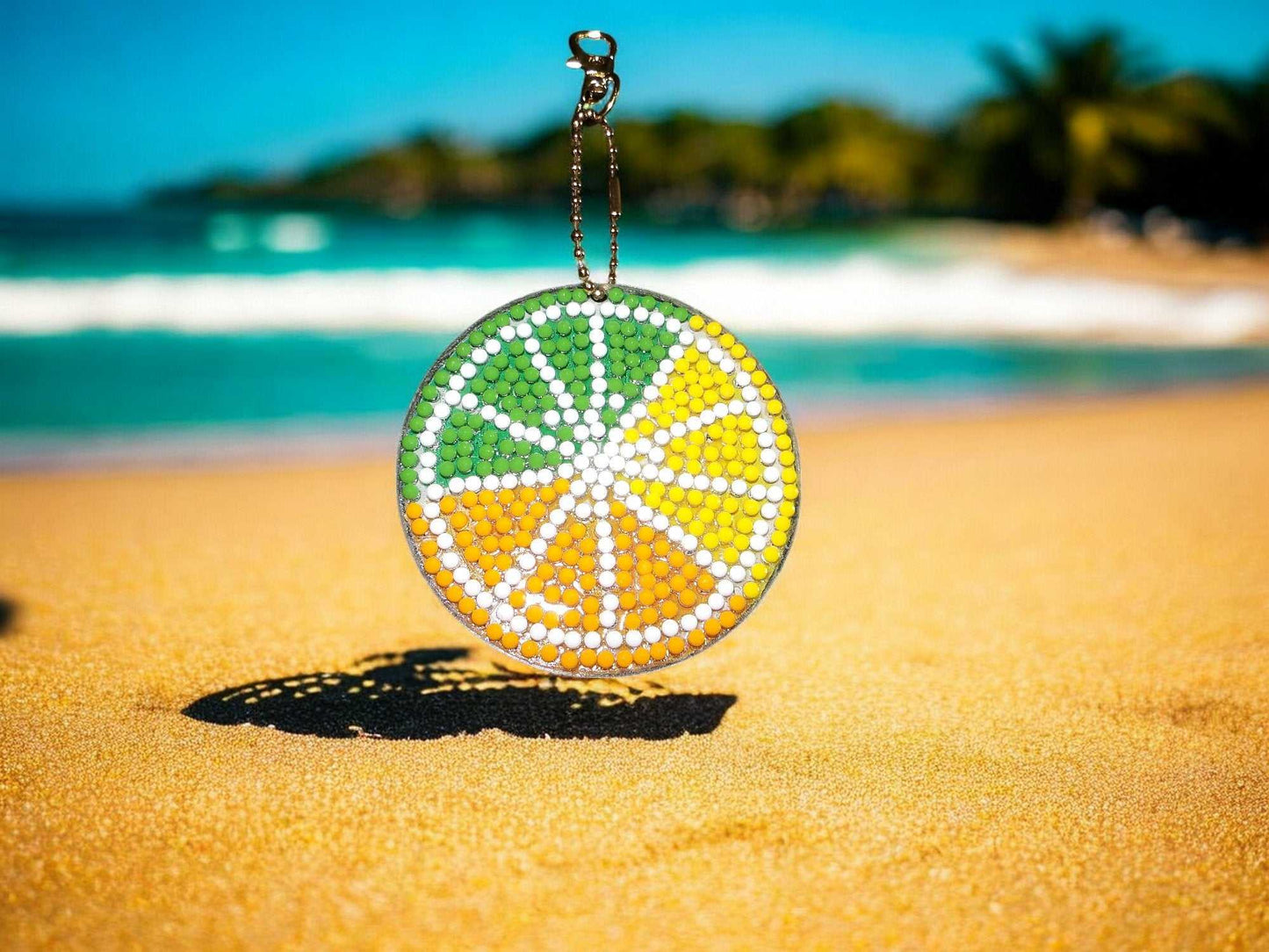 Colorful citrus pie keychain hanging on a sandy beach background