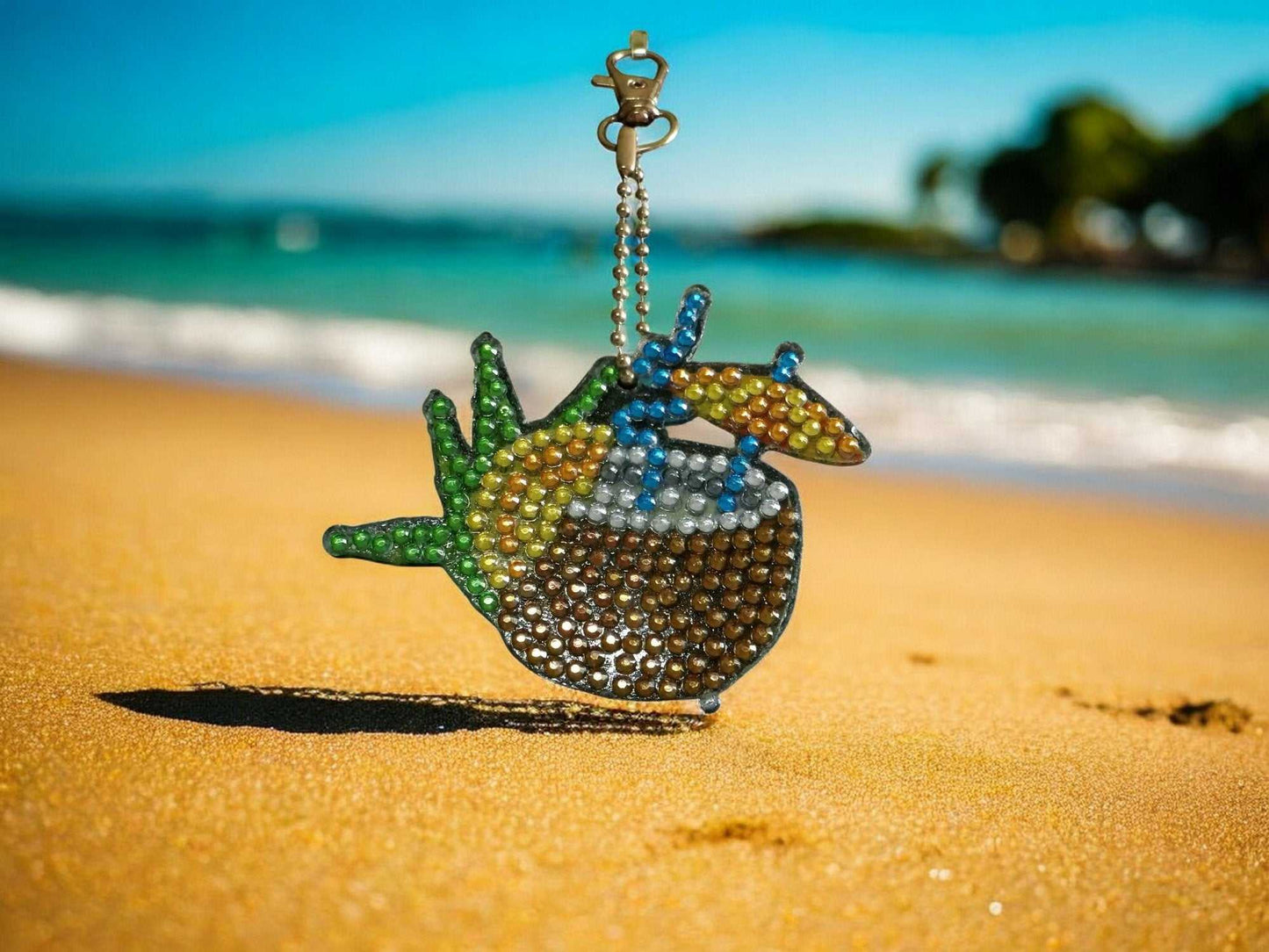 Summer Drink with Umbrella keychain sparkling on sandy beach background