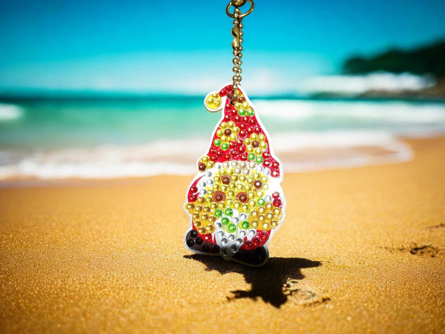 colorful flower pot gnome keychain with beads hanging on a beach background