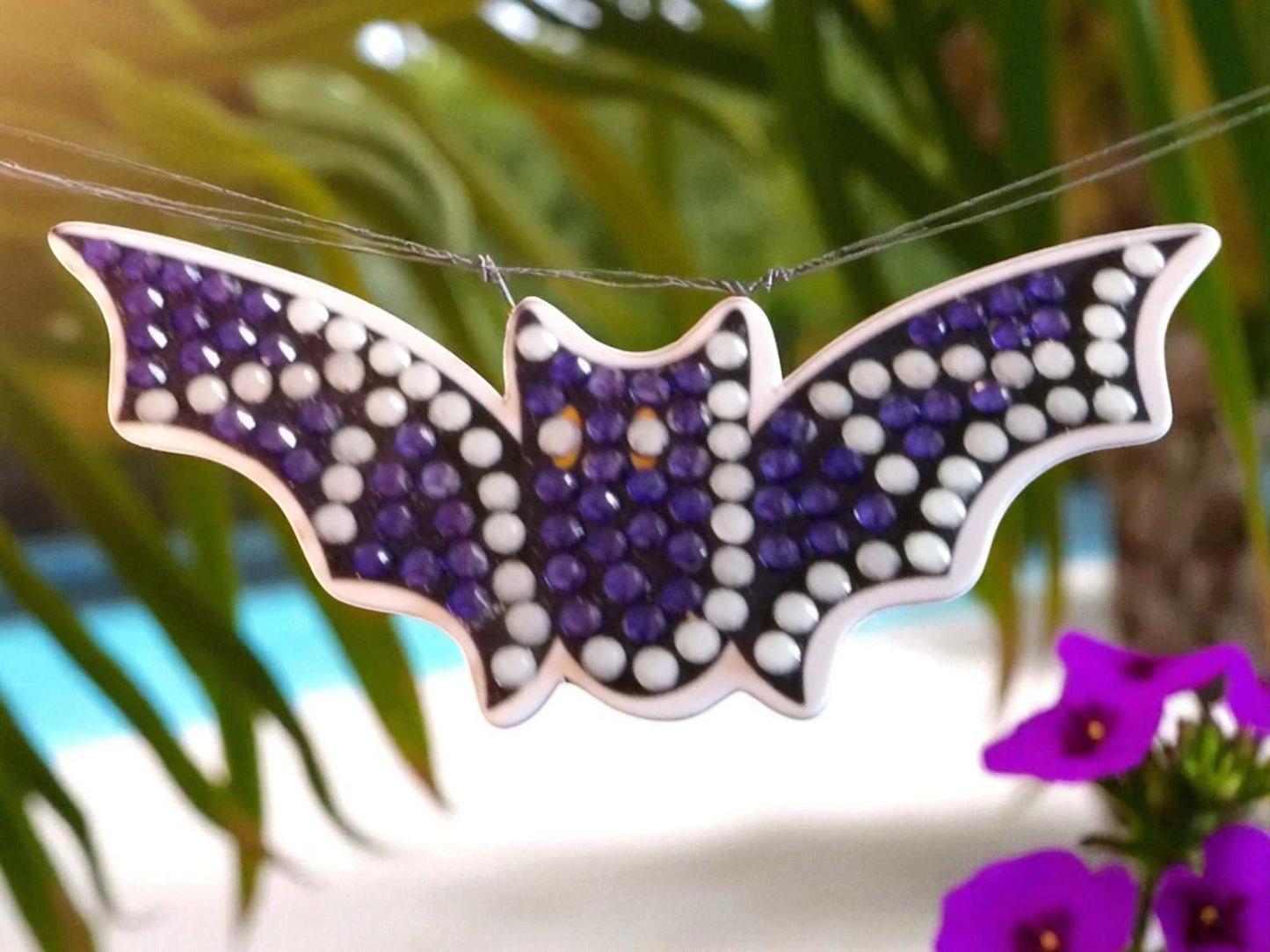 Glow in the dark flying bat magnet decorated with purple and white rhinestones
