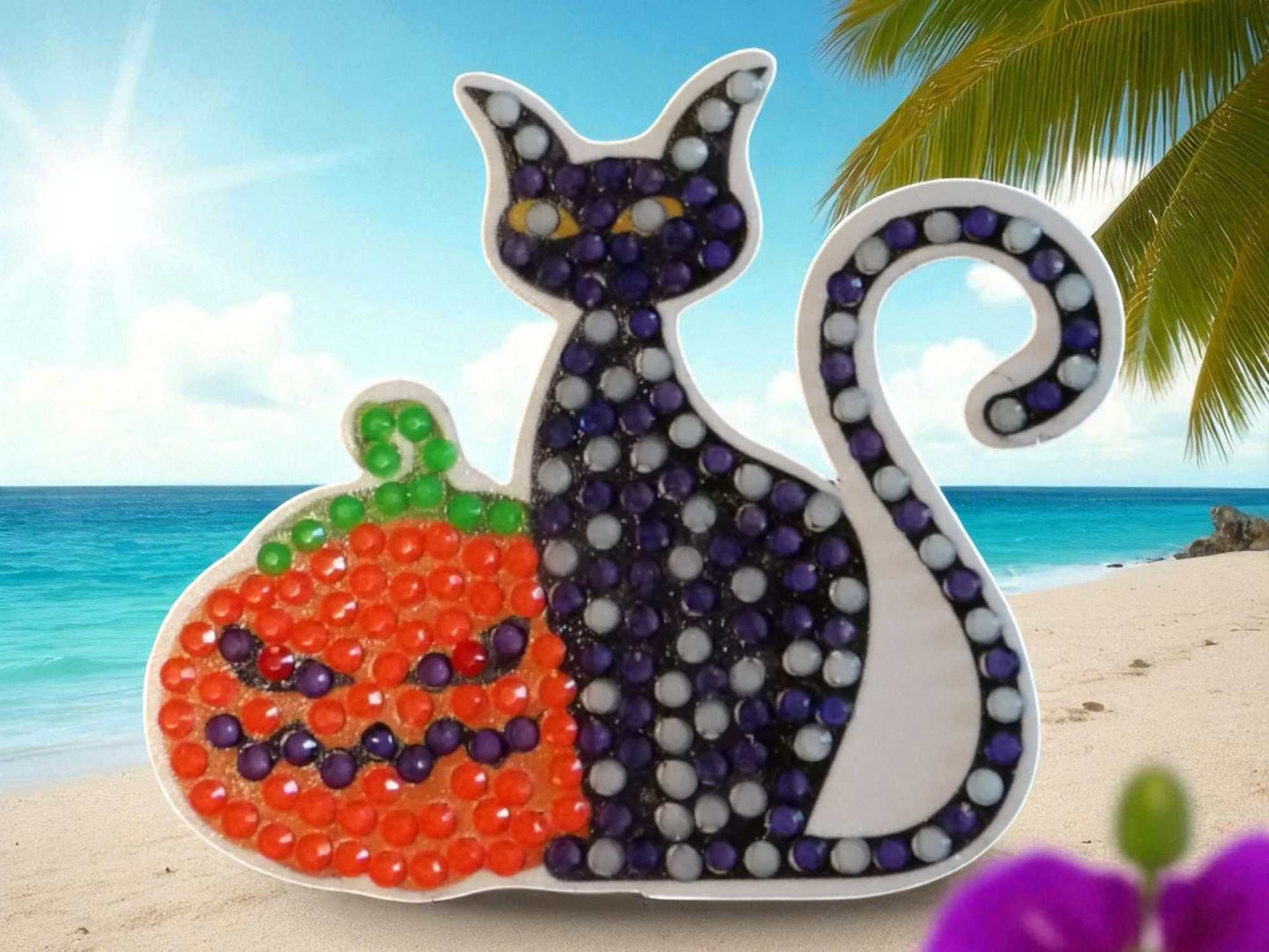 Glow in the dark black cat magnet with pumpkin design on beach background