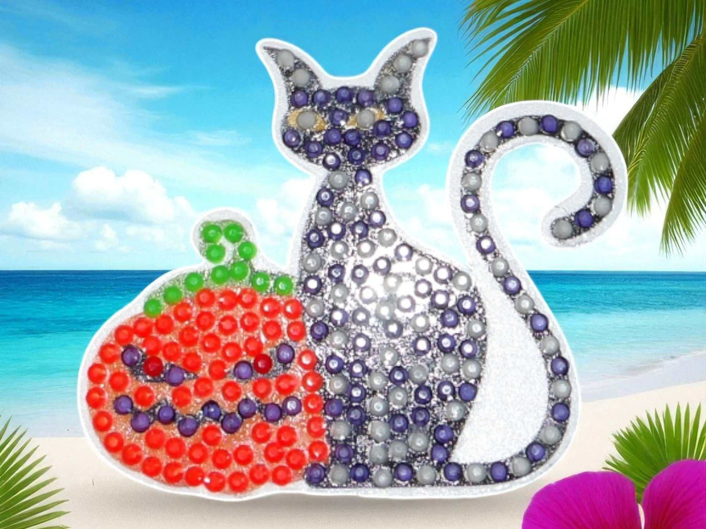 Glow in the dark black cat with pumpkin magnet decorated with colorful beads against a beach background