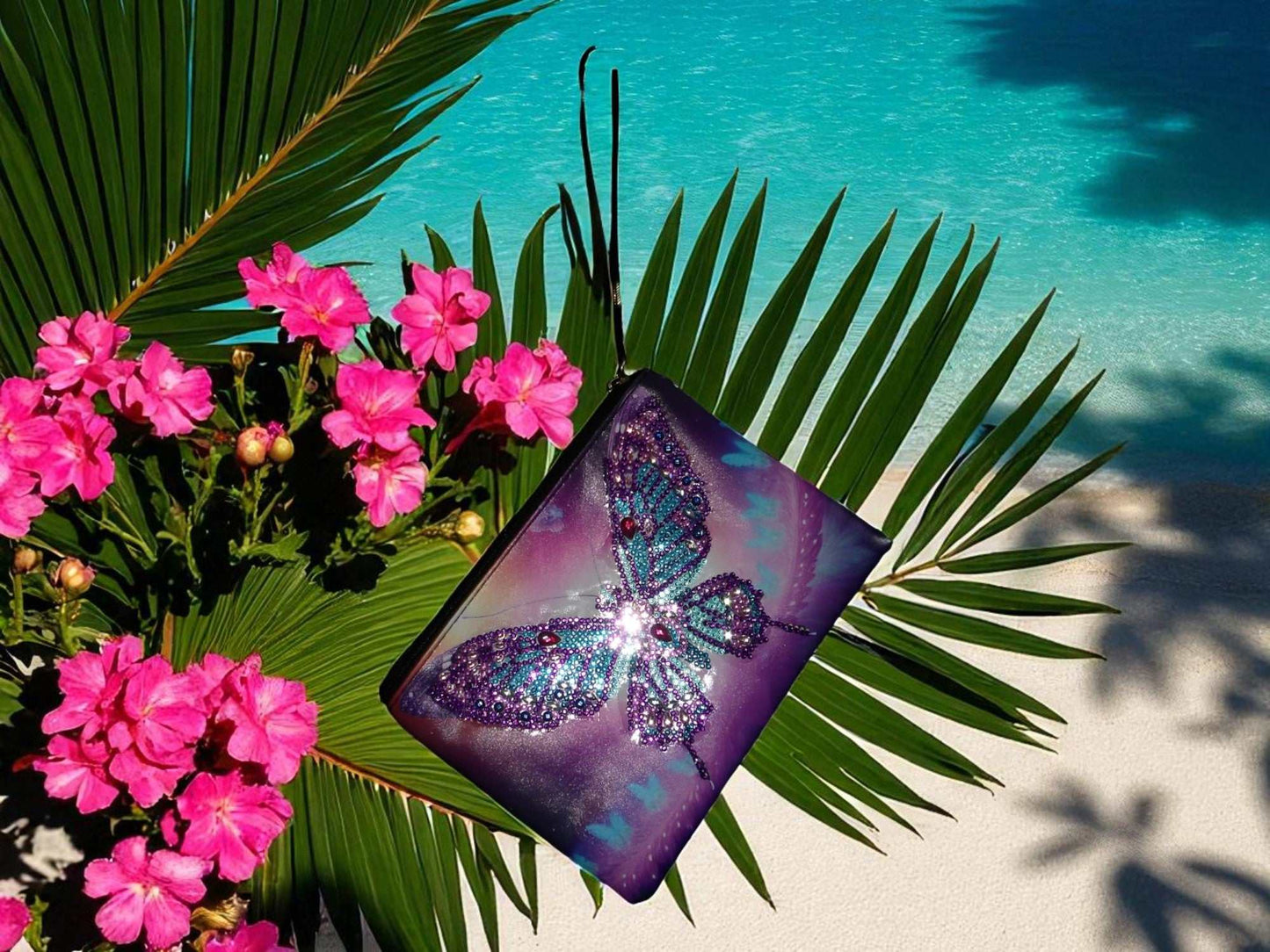 Large purple blue butterfly hand clutch with sparkling butterfly design on tropical leaves background near pool