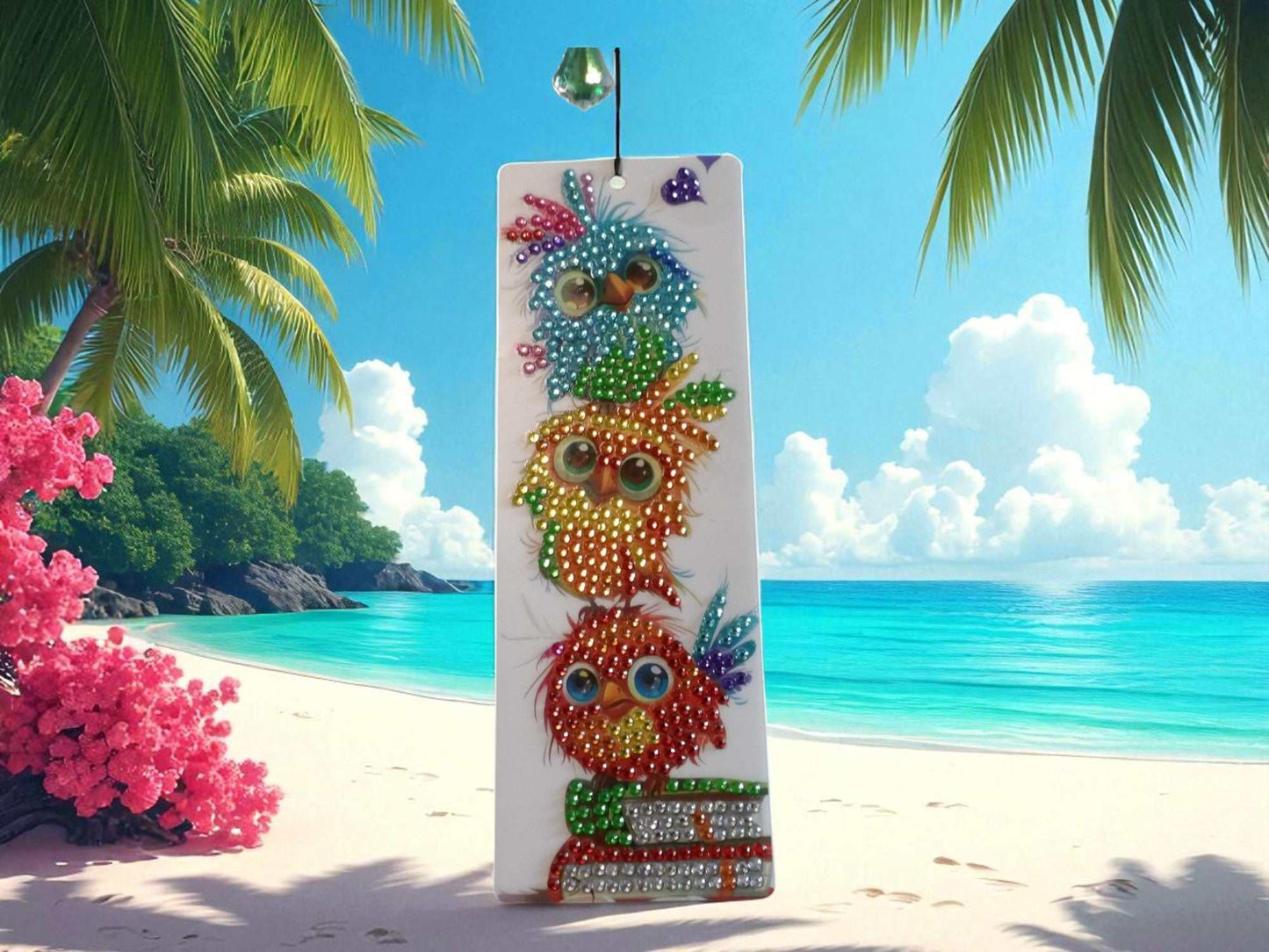 Playful colorful birds bookmark with vibrant bird illustrations and rhinestone embellishments against a beach background