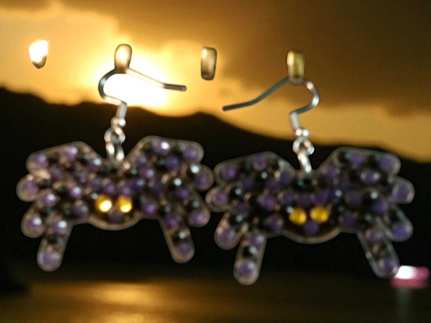 Glow in the dark spider shaped handmade earrings with purple and yellow accents