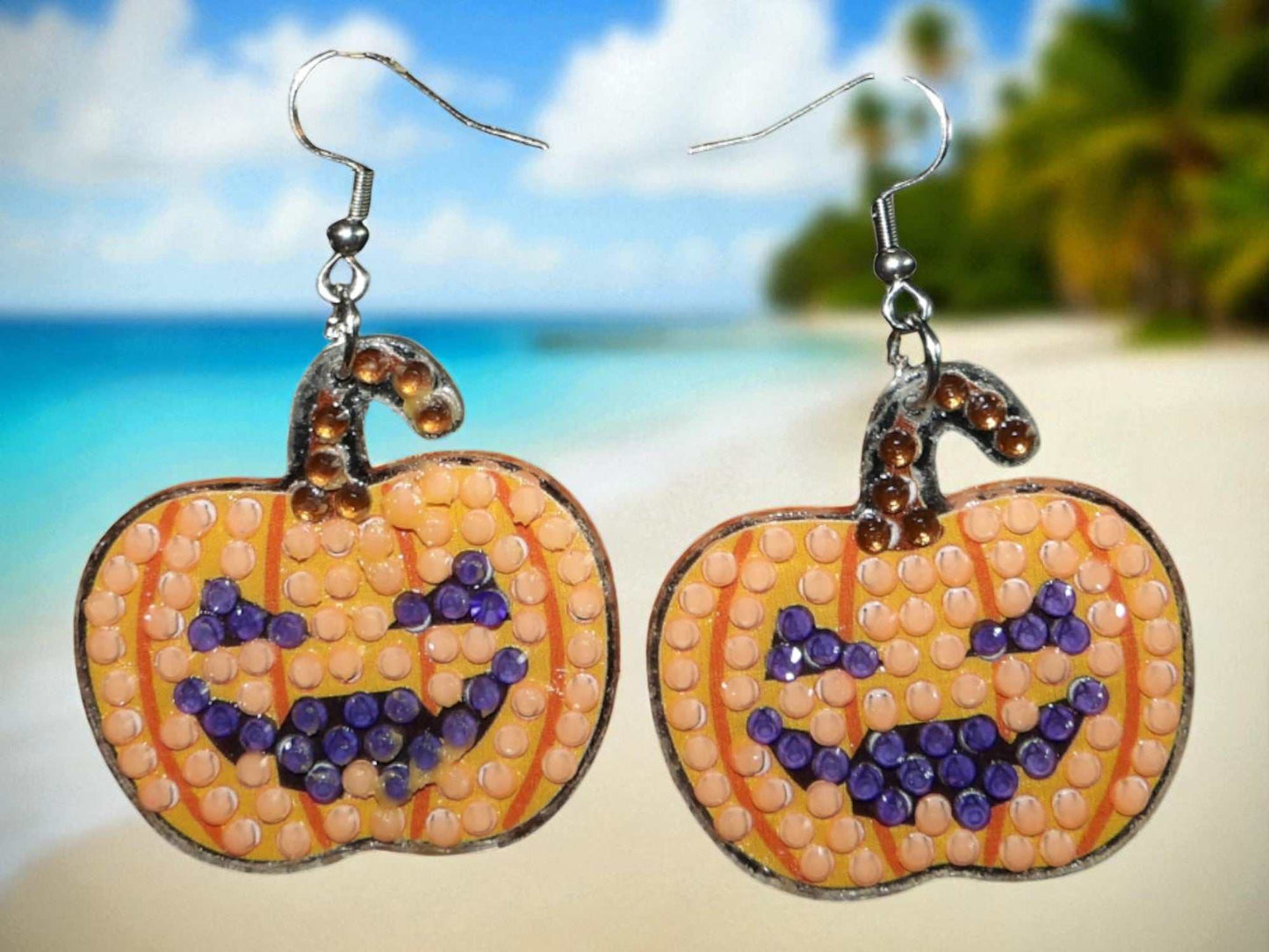 Pair of handmade glow in the dark pumpkin earrings with smiling jack-o-lantern faces