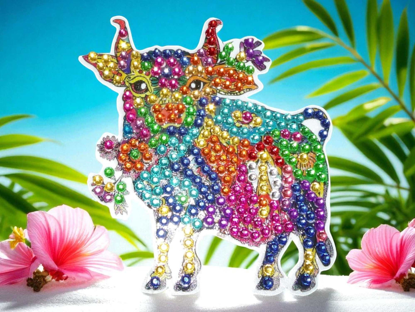 Colorful bull-shaped decorative magnet adorned with multicolored beads on tropical background