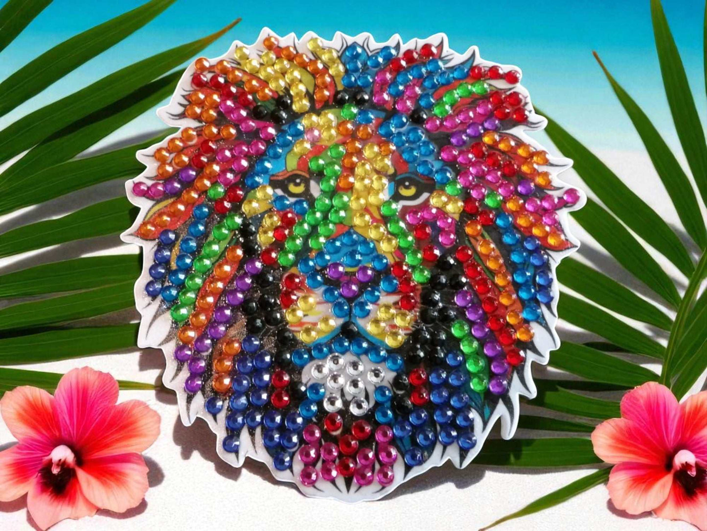 Colorful lion's head magnet decorated with multicolored rhinestones surrounded by tropical leaves and flowers