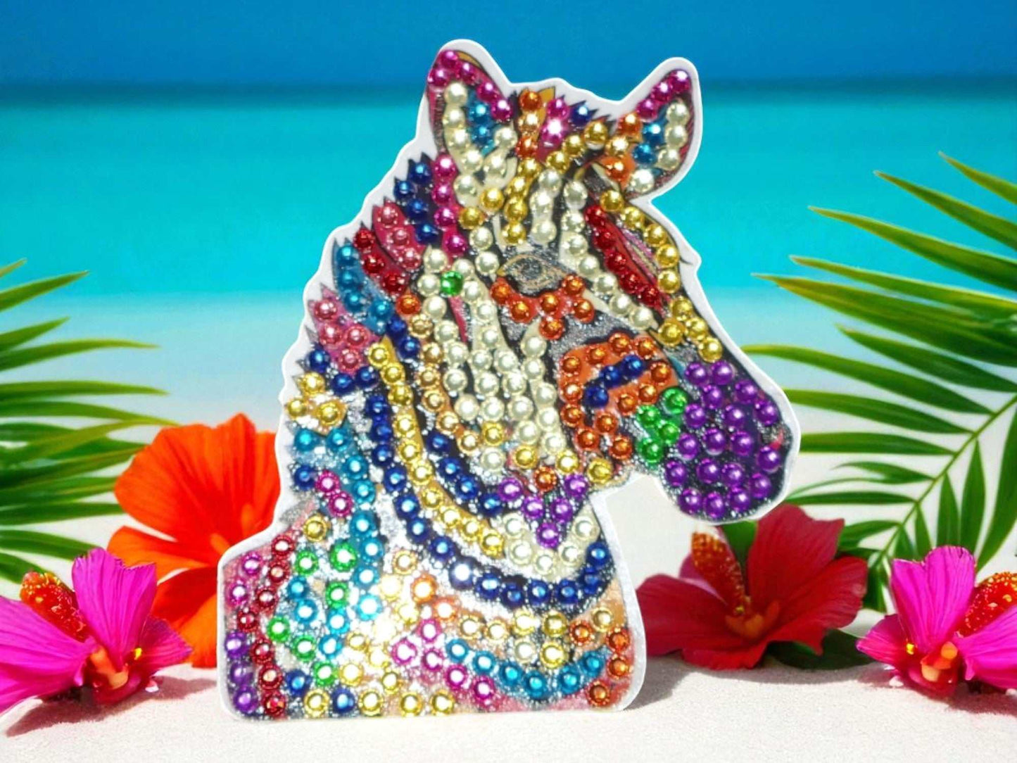 Colorful zebra head magnet decorated with vibrant beads among tropical flowers
