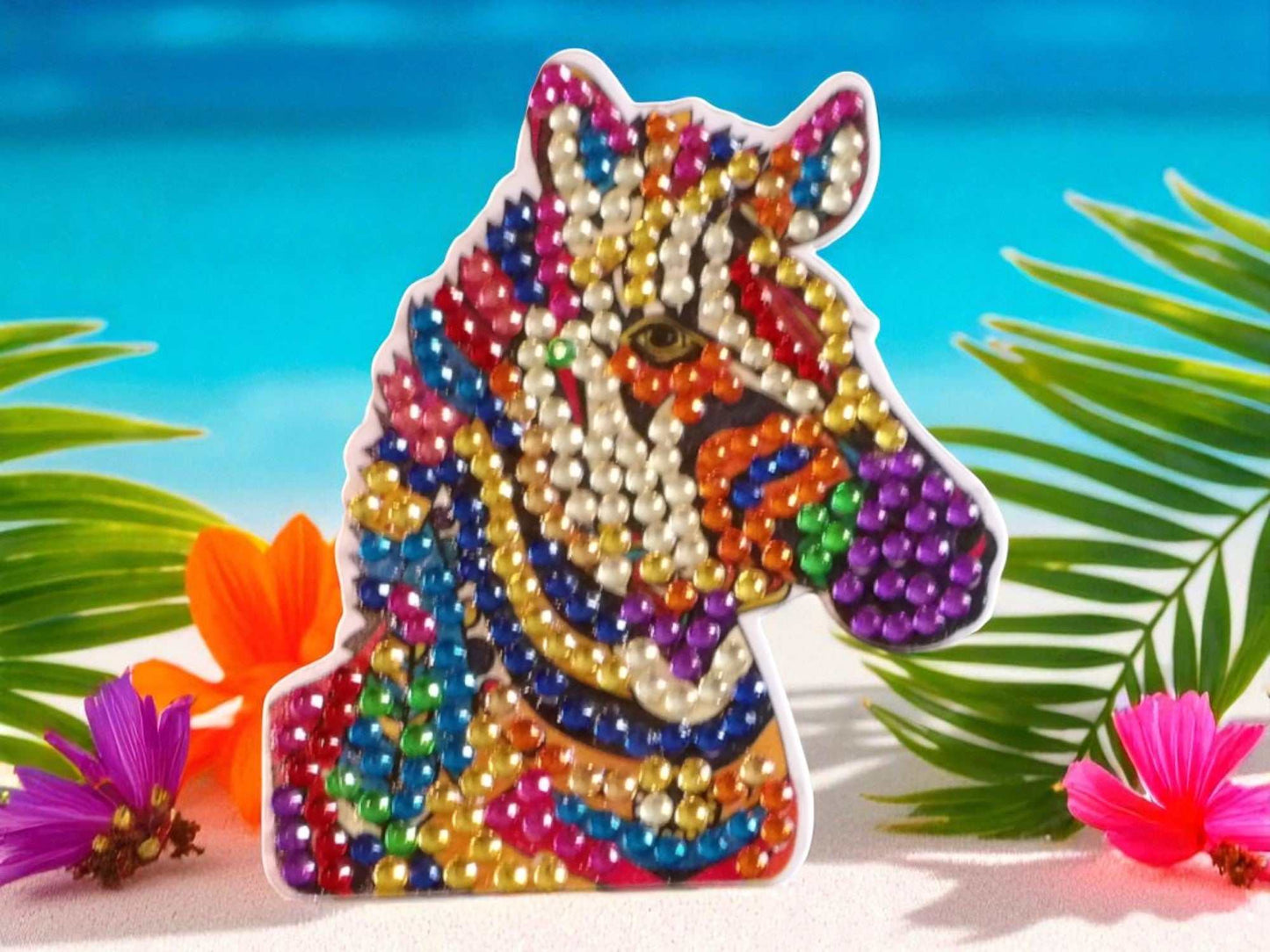 Colorful zebra head magnet decorated with vibrant beads on tropical background