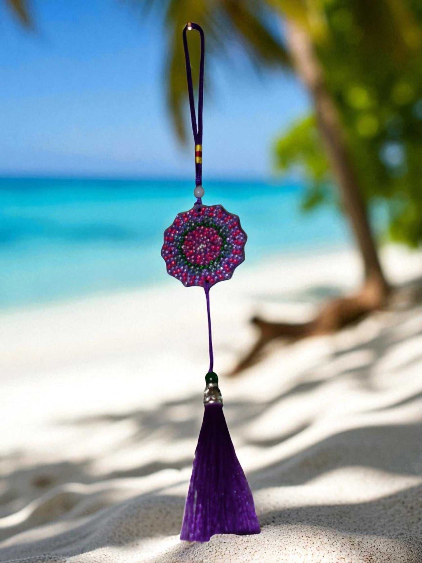 Deep blue colorful design hanging car ornament with purple tassel on beach background