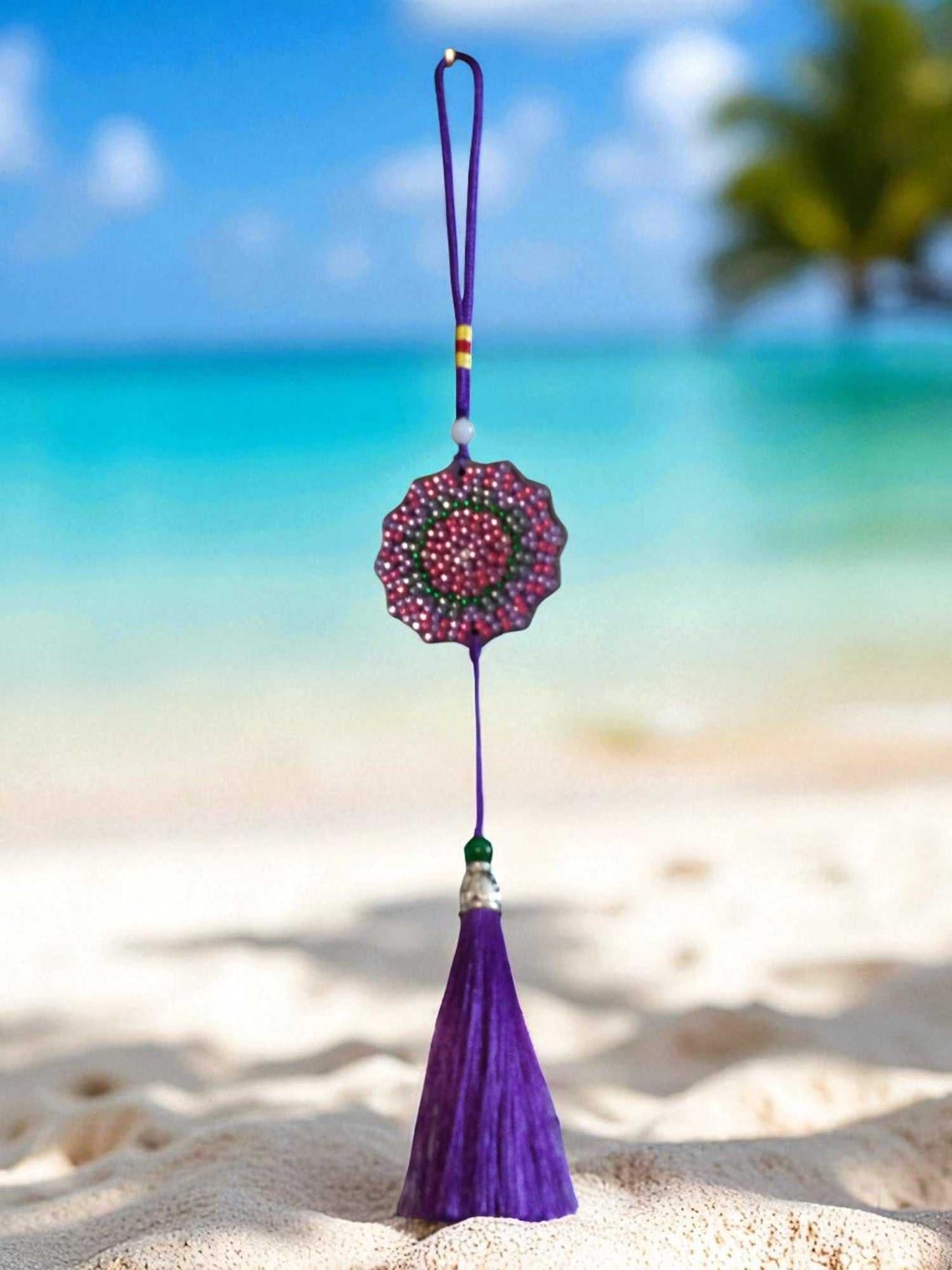 Deep Blue Colorful Design car ornament with purple tassel hanging on beach background