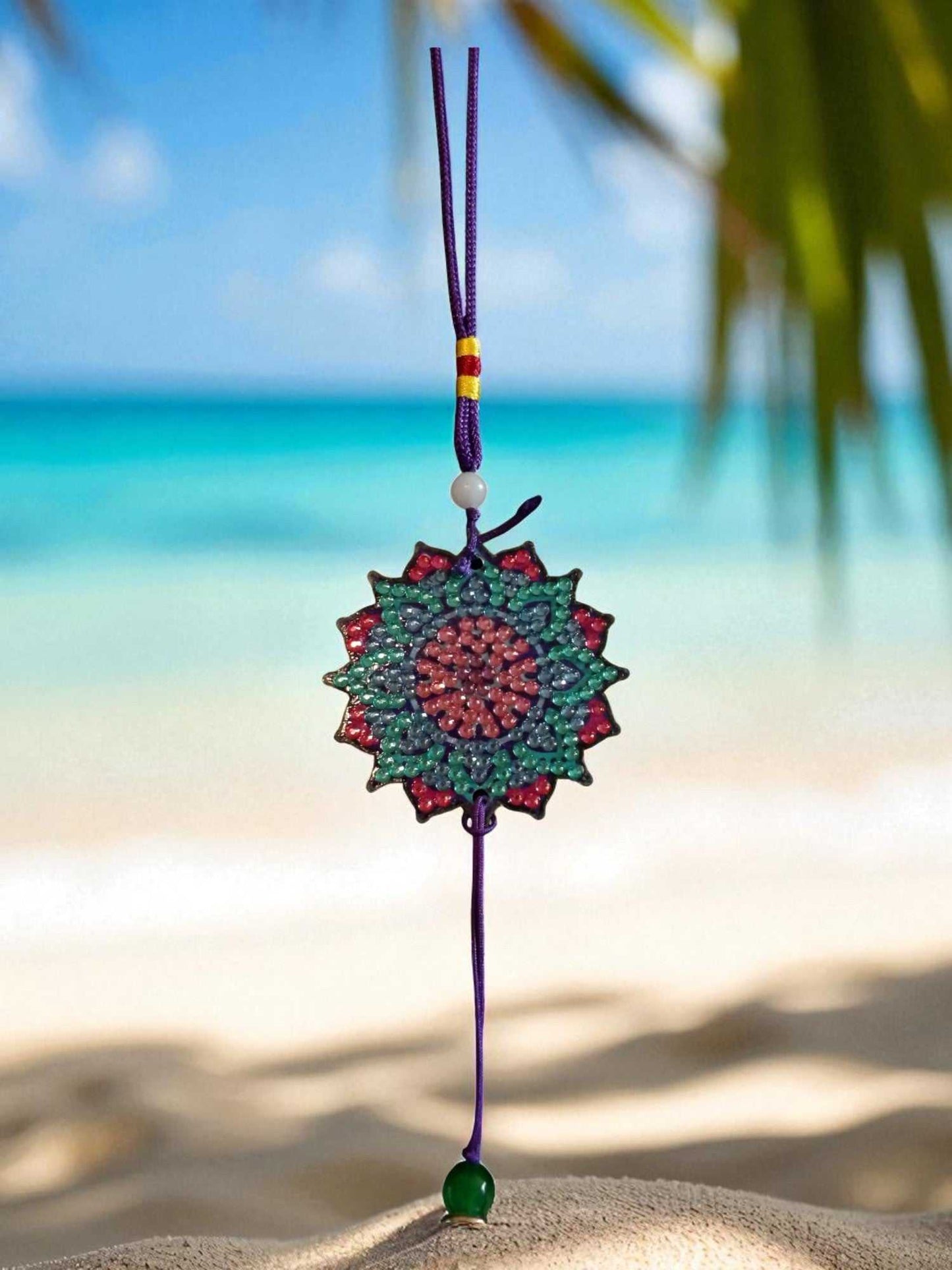 Navy blue colorful design car ornament hanging on purple string with beach background