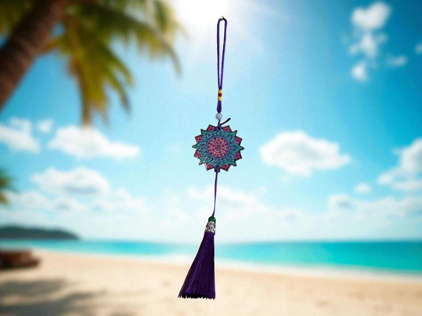 Navy blue colorful design car ornament hanging with tassel and floral pattern on beach background