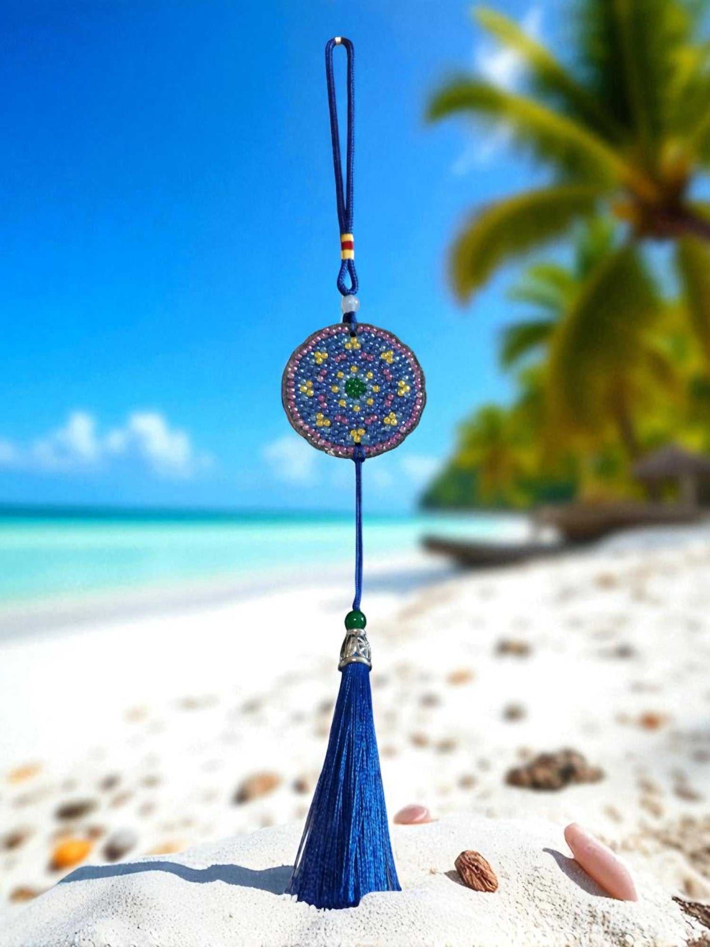 Blue & Yellow colorful design car ornament with tassel hanging on beach background