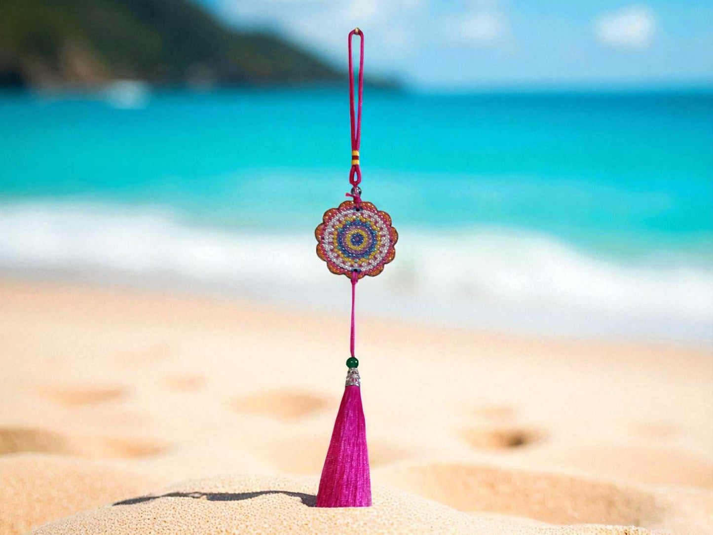 Pink colorful design car ornament hanging with tassel on beach background