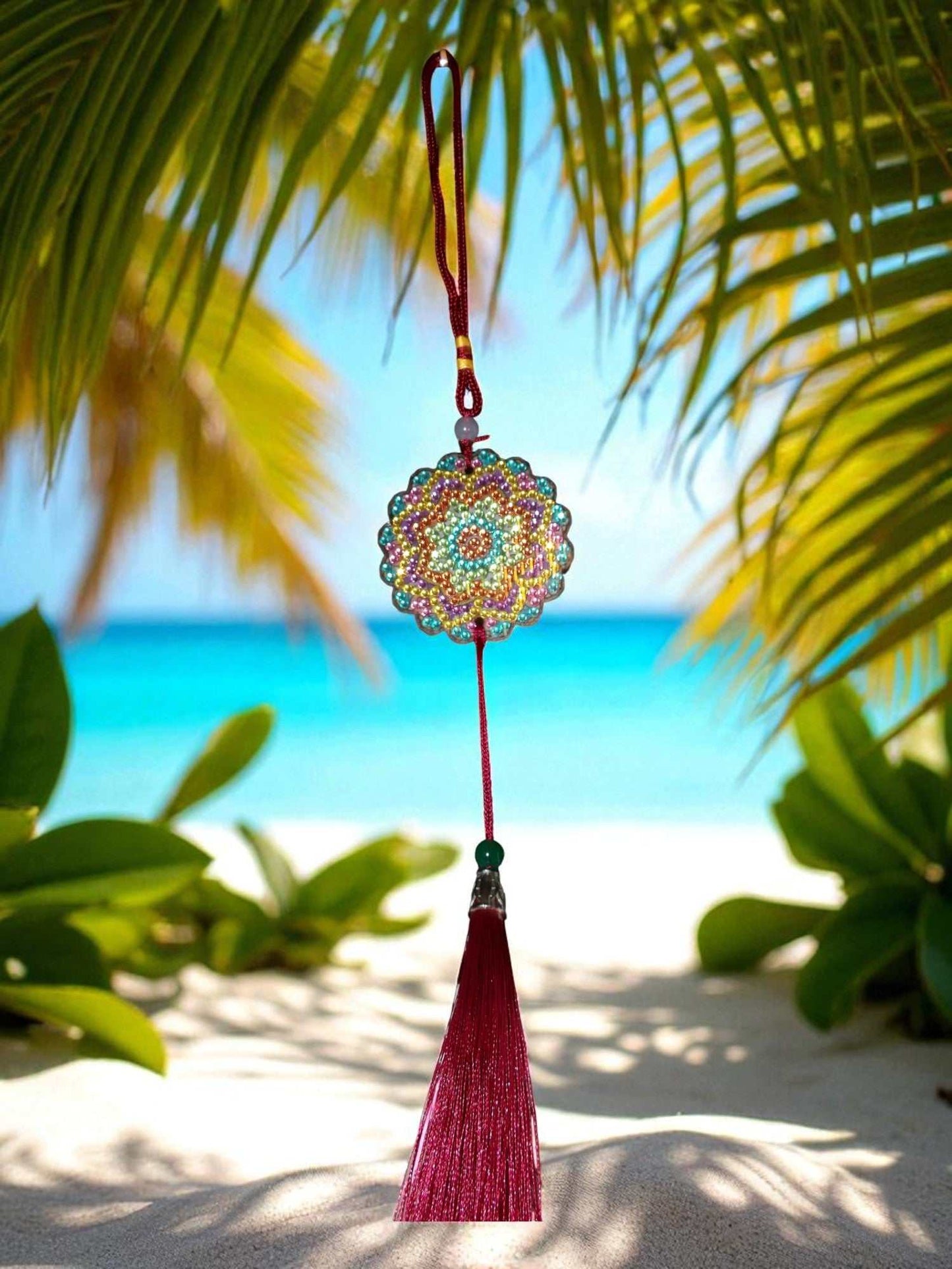Pink Blue Yellow colorful design car ornament hanging with red tassel against tropical beach background