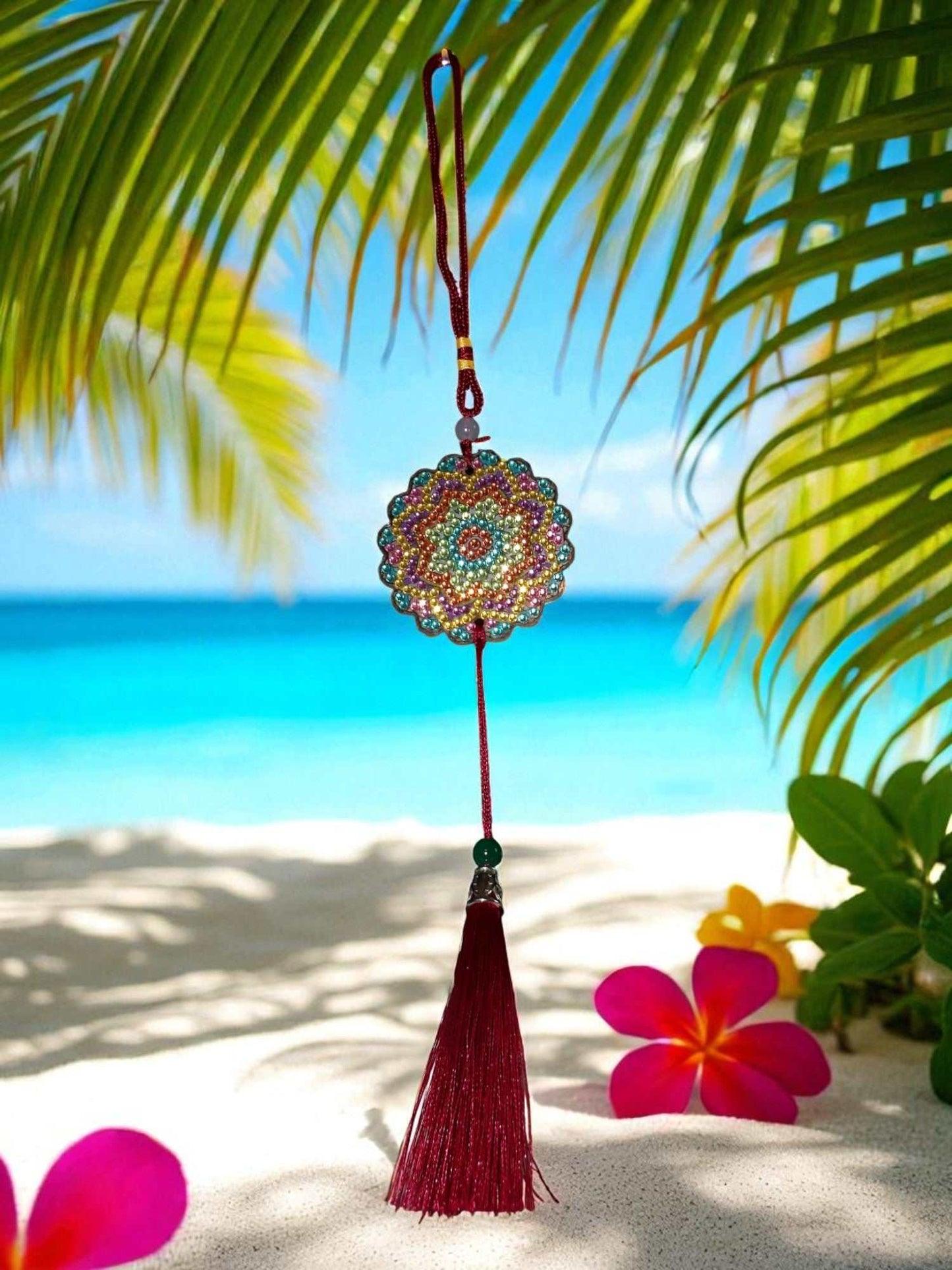 Pink Blue Yellow Colorful Design car ornament with tassel hanging on a tropical beach background