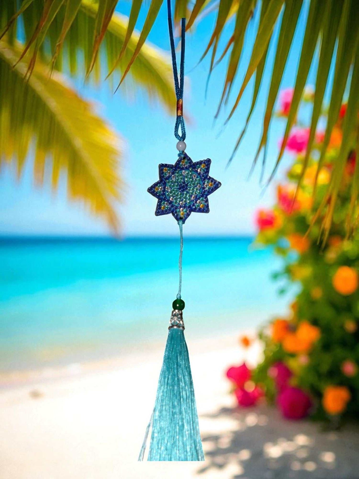 Light Blue Star colorful car ornaments hanging with beach background and palm leaves