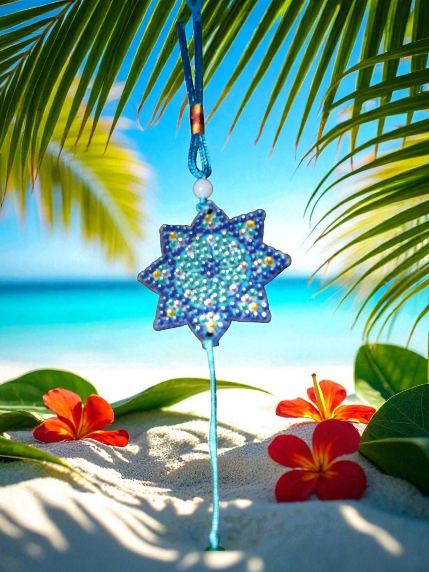 Light Blue Star colorful car ornaments hanging with tropical flowers and beach background