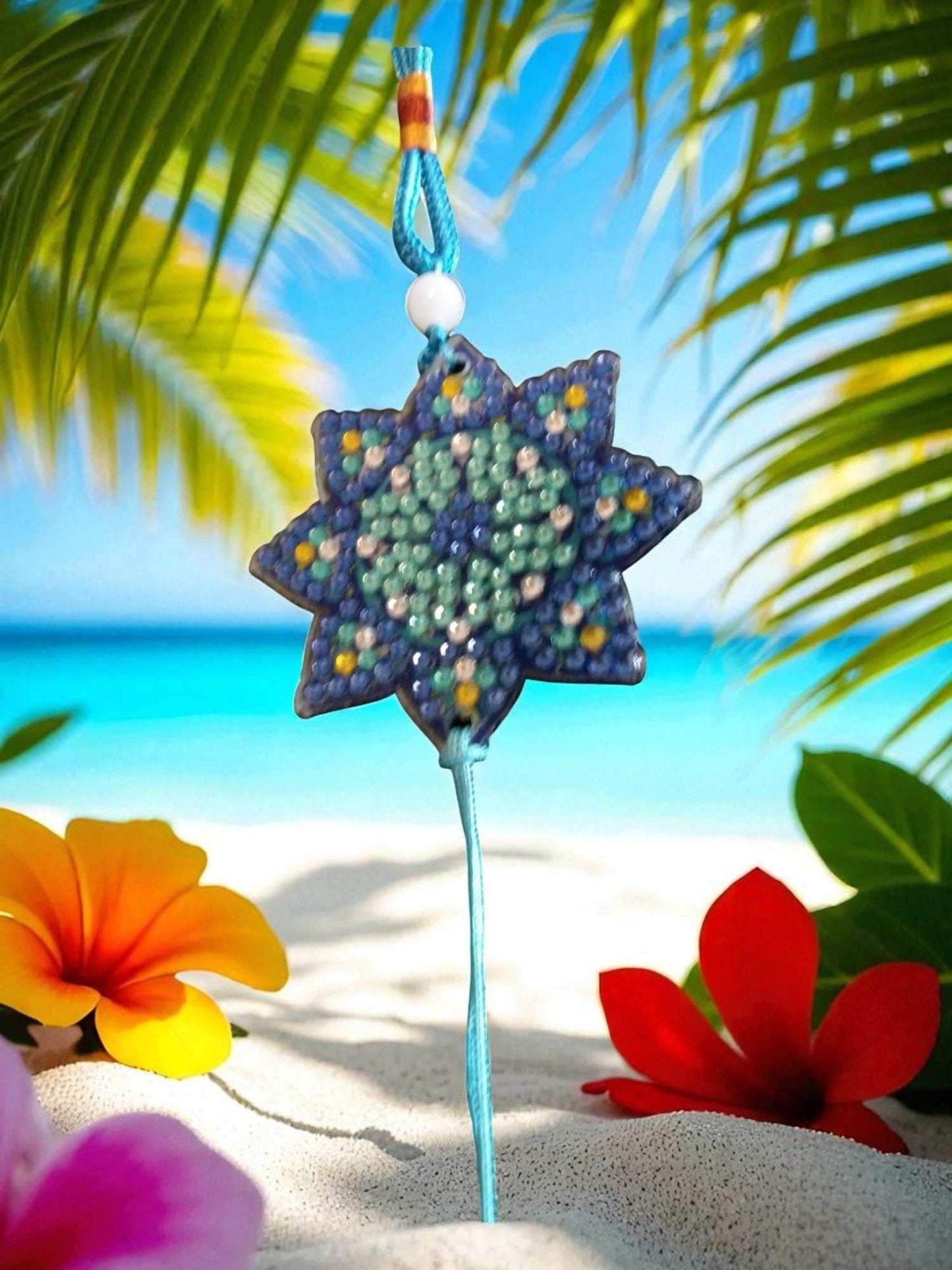 Light Blue Star colorful beaded car ornaments hanging with tropical beach background
