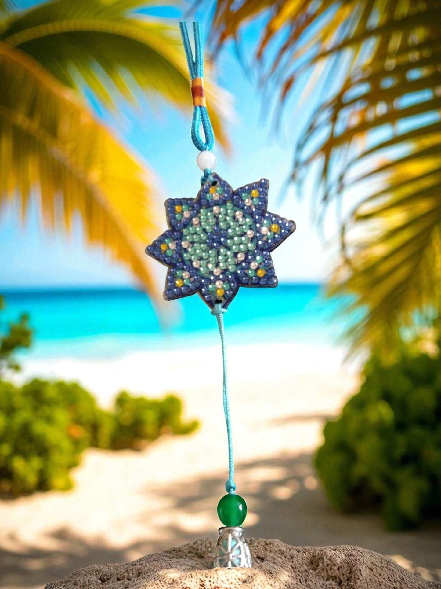 Light Blue Star colorful beaded car ornaments hanging with beach background