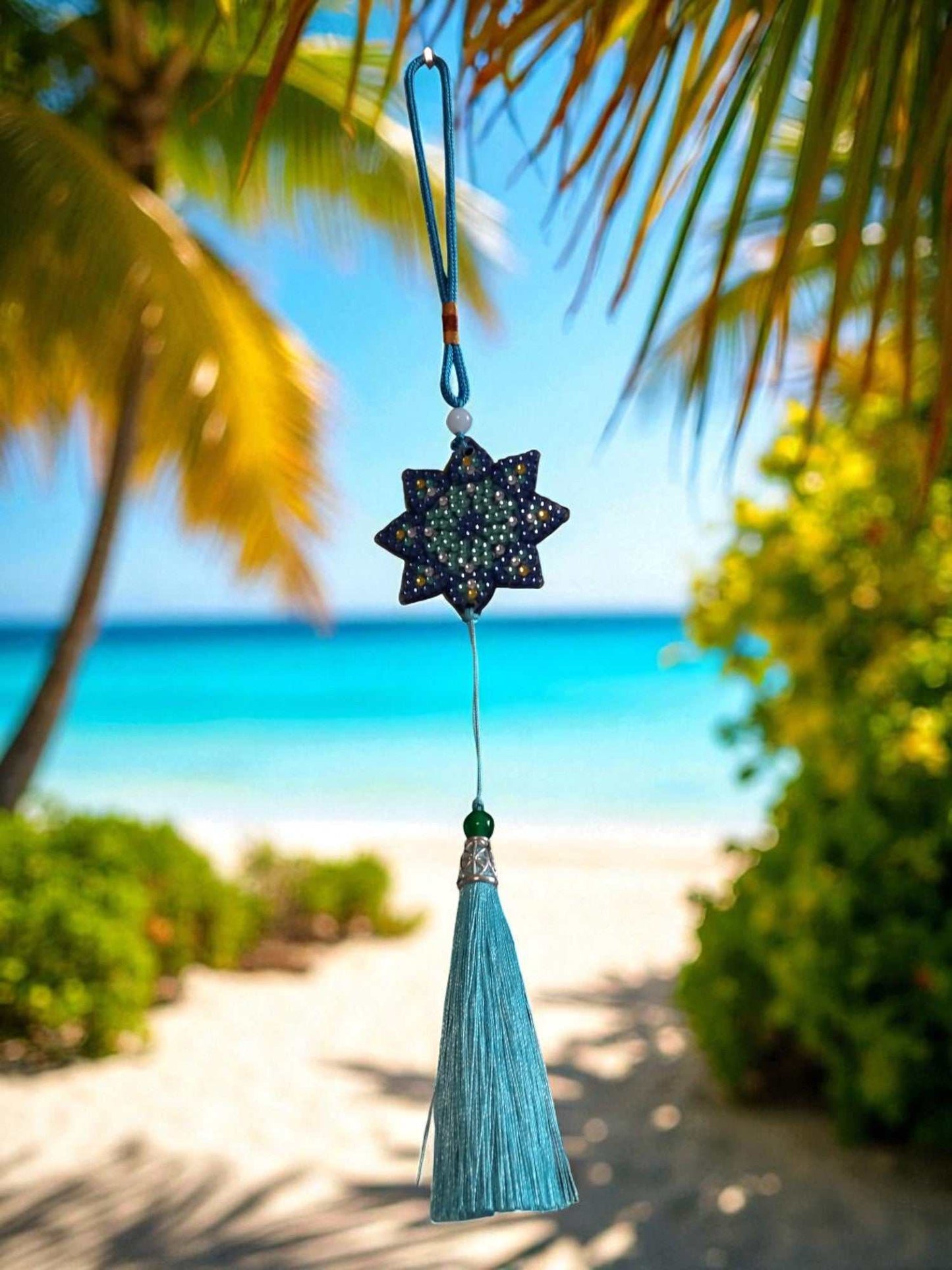 Light Blue Star colorful car ornaments hanging with tassel by beach background