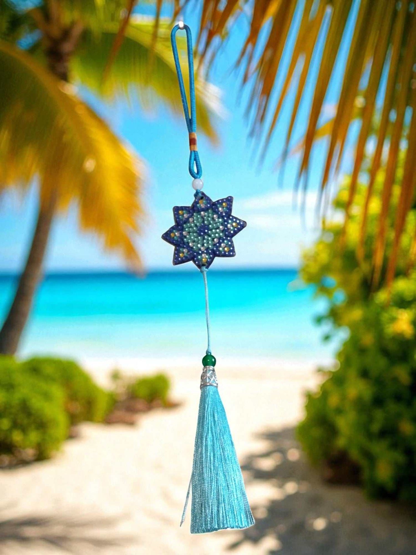 Light Blue Star colorful car ornaments with tassel hanging against tropical beach background