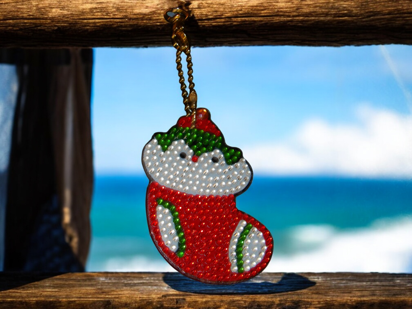 Penguin in Christmas stocking keychain hanging with ocean background
