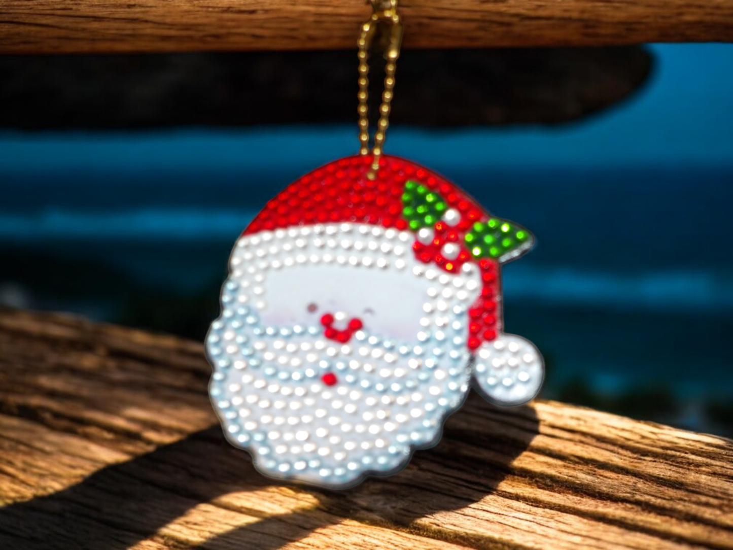 Santa Clause Face Keychain with red hat and white beard hanging on a gold chain