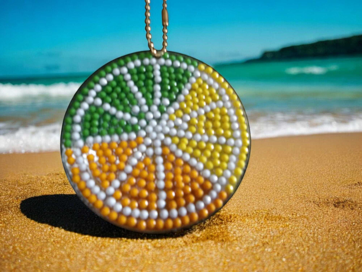 Citrus Pie Keychain with colorful bead design on beach sand background