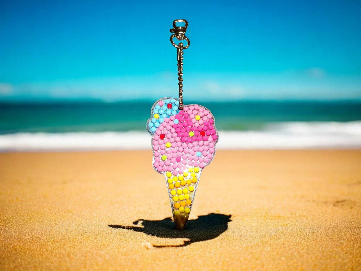 Colorful ice cream cone keychain with beads hanging at the beach with ocean background
