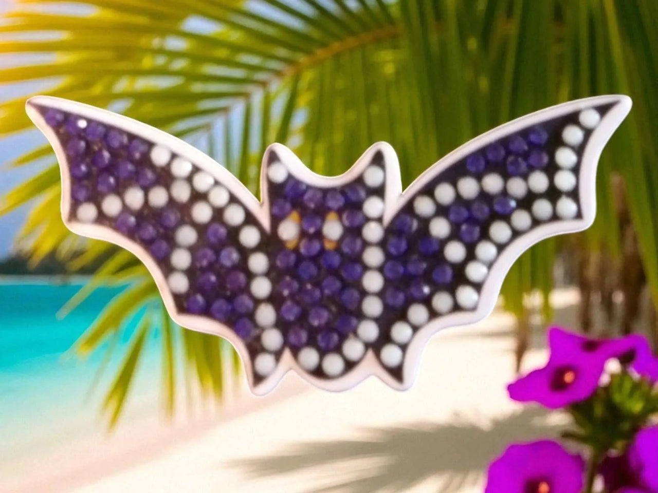 Glow in the dark purple and white flying bat magnet on tropical background