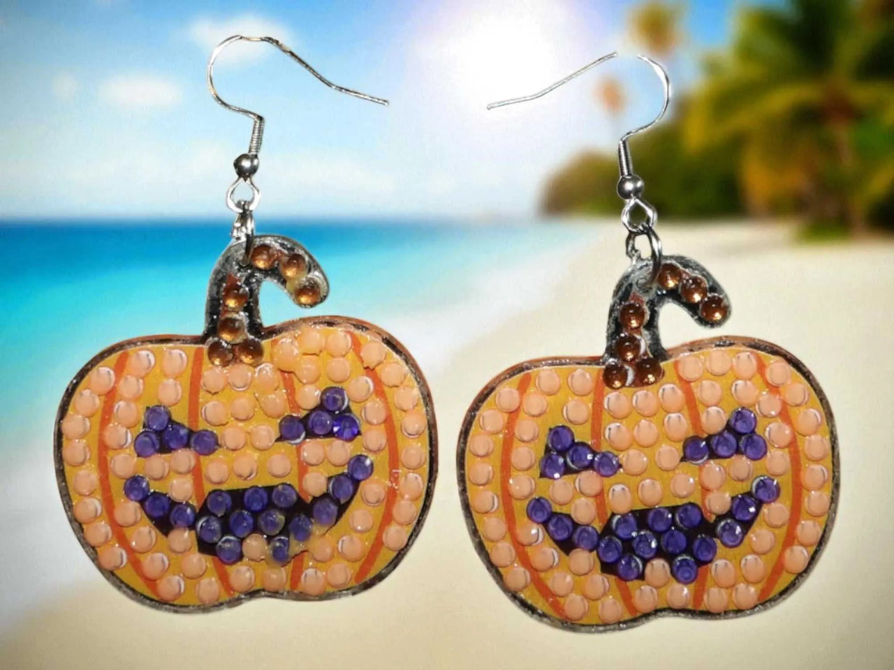 Glow in the dark pumpkin earrings with beaded jack-o'-lantern design and silver hooks