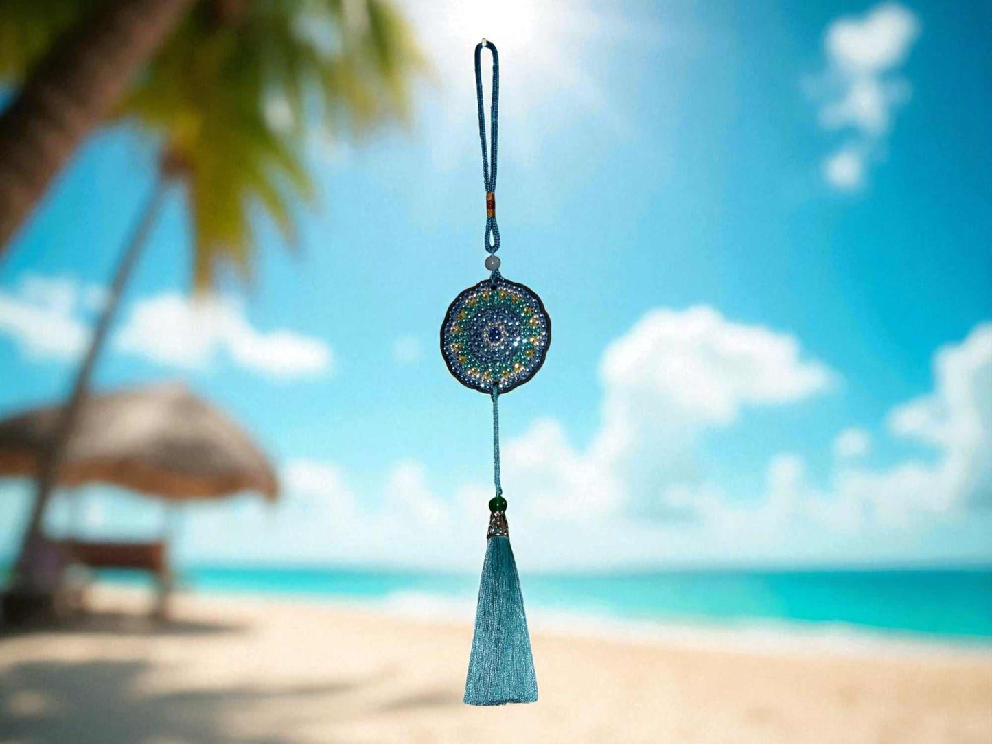 Sky blue colorful car ornament hanging with tassel against beach background