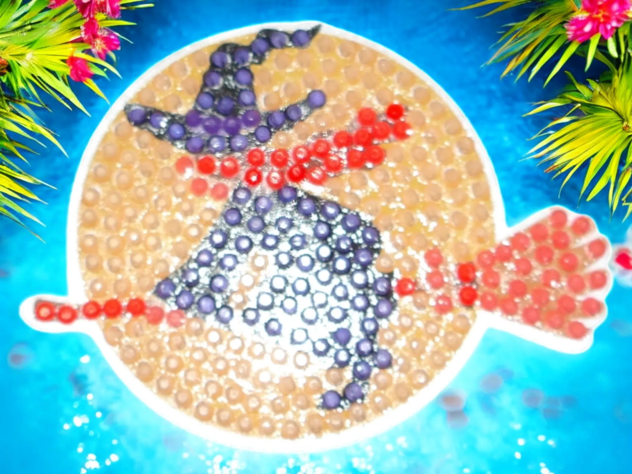 Glow in the dark magnet featuring a flying witch against an orange moon design