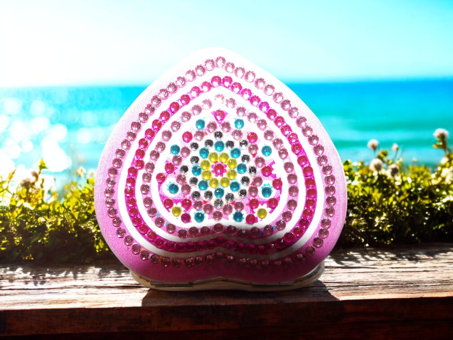 Pinkish heart shaped pocket mirror with colorful mandala design and magnification feature